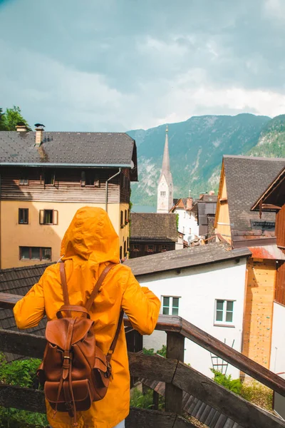 Γυναίκα Κίτρινο Αδιάβροχο Κοιτάζοντας Hallstatt Πόλη Συννεφιασμένο Βροχερό Καιρό — Φωτογραφία Αρχείου