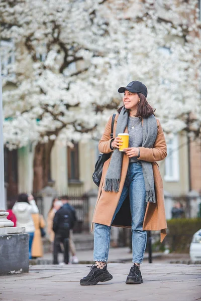 Jonge Stijlvolle Vrouw Lopen Door Straat Met Koffiekop Lente Bloeiende — Stockfoto