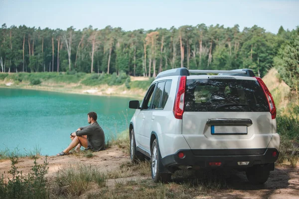 Homem Sentado Perto Carro Branco Suv Borda Olhando Para Lago — Fotografia de Stock