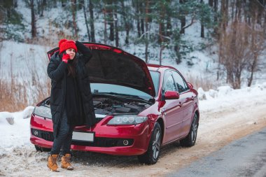 Kış karayolunda yardım isteyen bir kadın yol kenarında durmuş.
