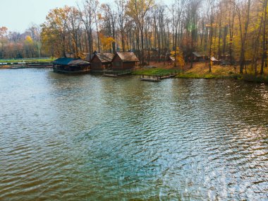 Göl kenarındaki sonbahar orman parkının havadan görüntüsü. İskeleler de bbq bölgesinde dinleniyor.