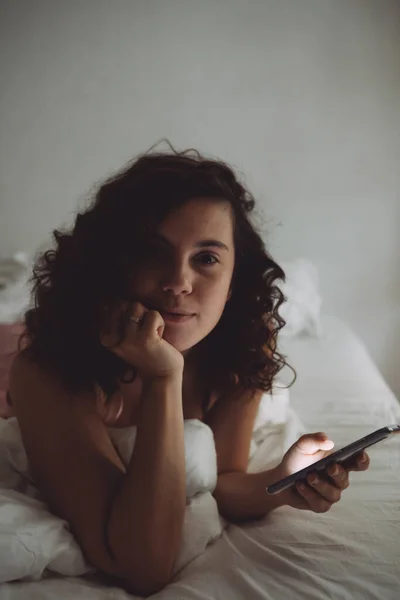 Jong Mooi Vrouw Met Krullend Haar Bed Met Telefoon Binnenlandse — Stockfoto