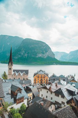 Hallstatt Kilisesi 'nde çan kulesi gölü ve arka planda dağları olan yaz mevsimi