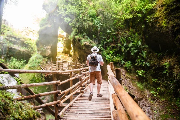 イタリアの木製のトレイルカリヨン洞窟を歩くバックパッカー 夏の旅行のコンセプト — ストック写真