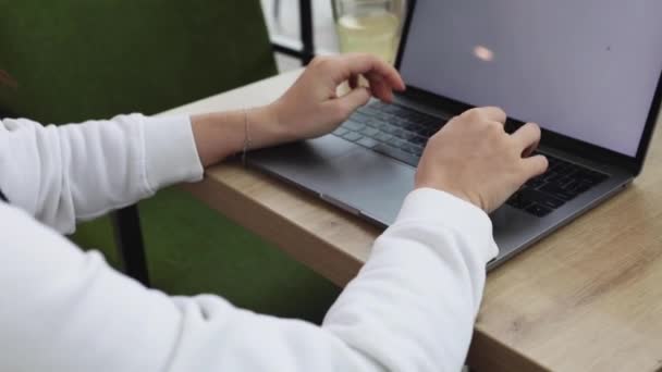 Vrouw hand toetsenbord op laptop in cafe freelance — Stockvideo