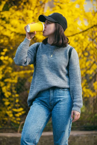 Młoda Stylowa Kobieta Czapce Pijąca Kawę Świeżym Powietrzu Żółtego Kubka — Zdjęcie stockowe
