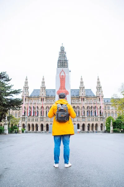 Tourist Man Looking Old City Hall Building Yellow Raincoat Spring — Stock Photo, Image