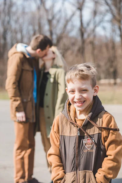 Niño Sonriente Delante Besando Los Padres Segundo Plano Temporada Otoño —  Fotos de Stock