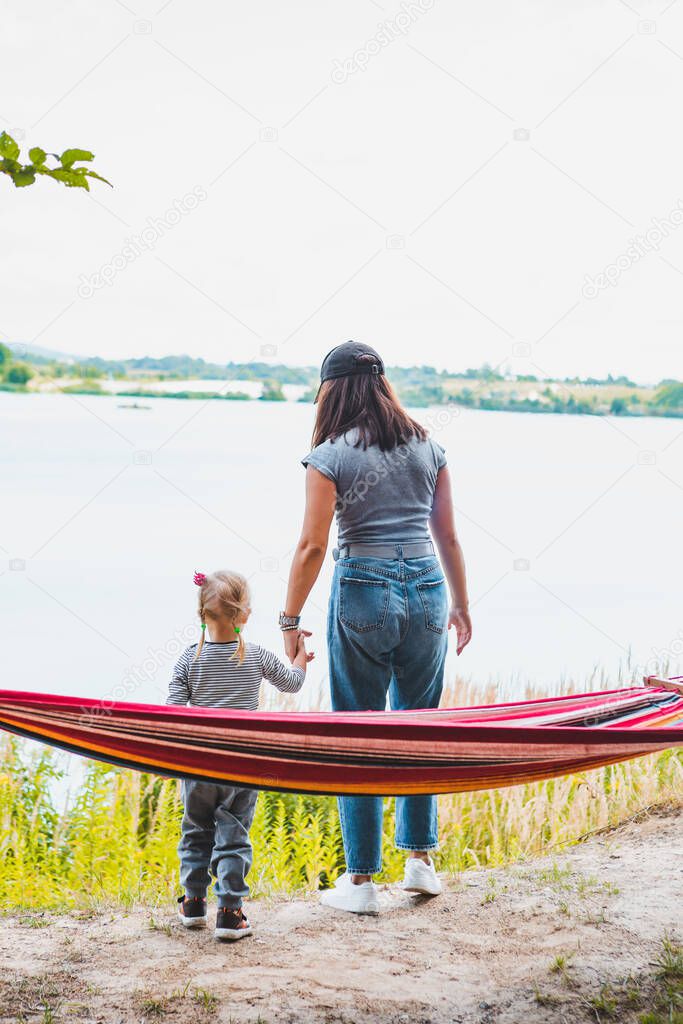 young pretty woman laying on hammock at lake beach summer time