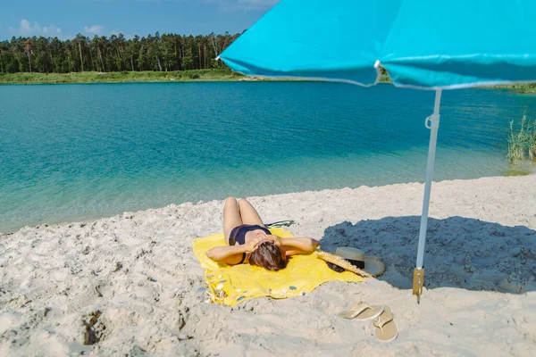 Frau Legt Sich Mit Blauem Sonnenschirm Auf Gelbe Decke Sandstrand — Stockfoto