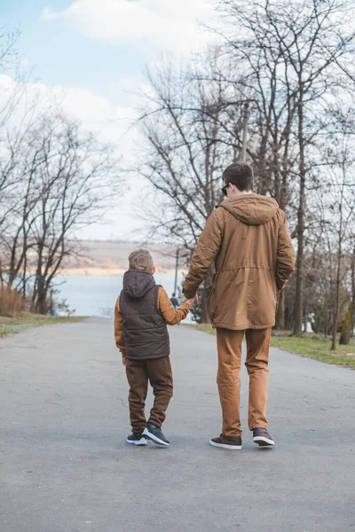 Padre Con Hijo Caminando Por Parque Tomados Mano Visión Trasera —  Fotos de Stock