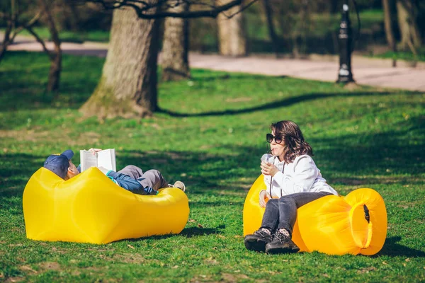 Paar Liegt Auf Gelber Aufblasbarer Matratze Stadtpark Lesebuch Smoothies Trinken — Stockfoto