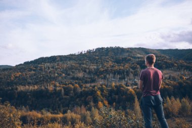Sonbahar ormanı dağlarına bakan adam uzayı kopyalıyor.