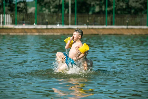 夏休みの楽しいアクティビティで水に息子を投げる父親 — ストック写真