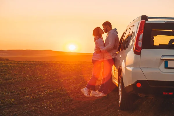 romantic moment couple kissing on sunset near white suv car copy space.