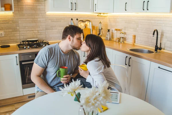 couple sitting at the kitchen in the morning drinking tea reading news. domestic lifestyle