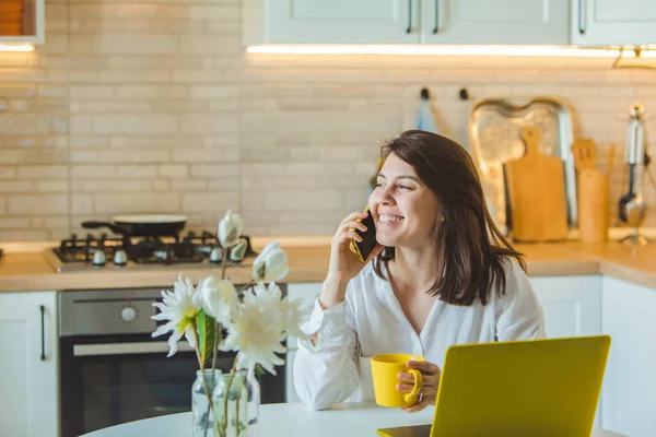 Jovem Muito Caucasiano Mulher Falando Telefone Sentado Frente Laptop Cozinha — Fotografia de Stock