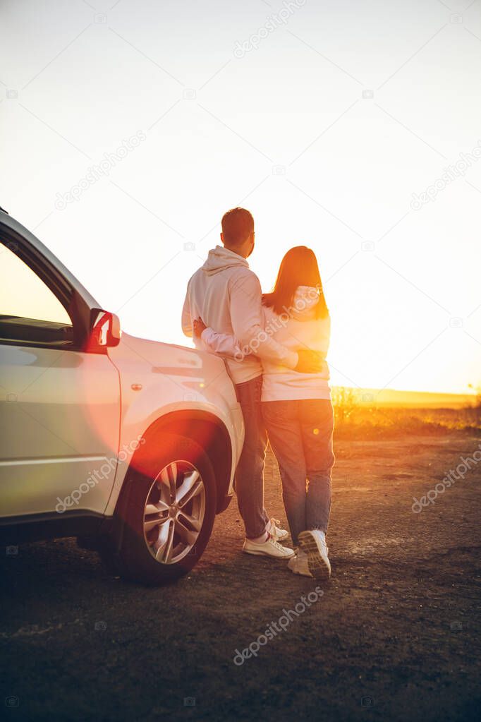 romantic moment couple looking on sunset near white suv car copy space.