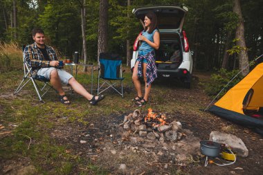 Portatif koltuklarda oturan bir çift çay içip sohbet ediyorlar. kamp yaz aktiviteleri kopyalama alanı