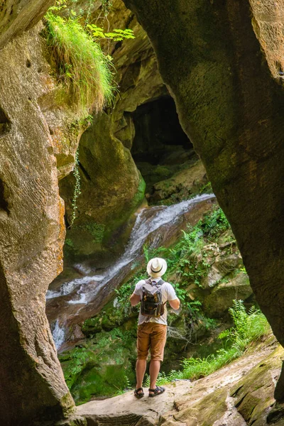 Young Adult Strong Man Backpack Cave Entrance Looking Sunlight Summer — Stock Photo, Image