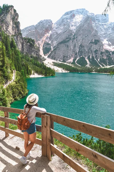 バックパックを持った藁帽子の女性が立ってドロマイトアルプスの湖を見ている 夏休みだ ハイキングだ コピースペース — ストック写真