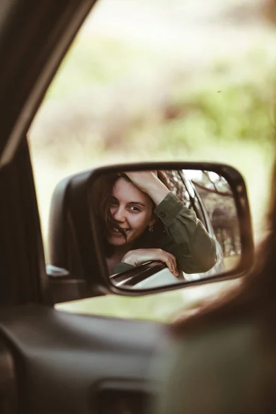 Refleksja Nad Oszałamiającą Uśmiechniętą Kobietą Tylnym Lusterku Samochodu Wynajem Samochodu — Zdjęcie stockowe