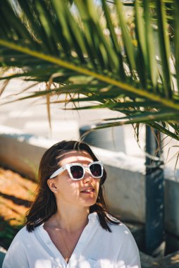 Palmiye yaprağının altındaki güzel kadınların portresi. sıcak gün