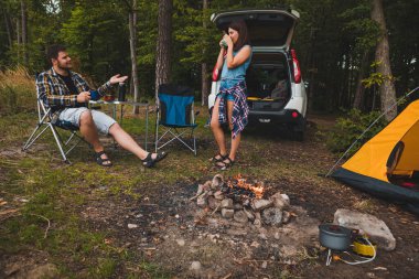 Portatif koltuklarda oturan bir çift çay içip sohbet ediyorlar. kamp yaz aktiviteleri kopyalama alanı
