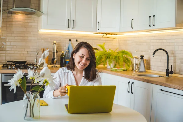 Mulher Bebendo Chá Caneca Amarela Trabalhando Laptop Cozinha Fundo Conceito — Fotografia de Stock