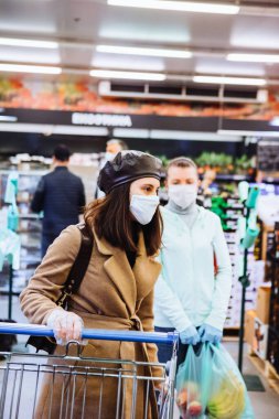 Tıbbi maskeli kadın market alışverişi yapıyor. kopyalama alanı. Coronavirus konsepti