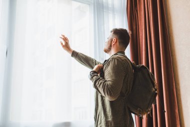 Sırt çantalı bir adam pencerenin yanında duruyordu. Boşluğu kopyala