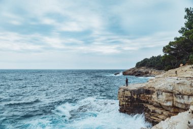 Adam kıyıda durup rüzgarlı havayı seyrediyor. Yaşam tarzı konsepti. yaz seyahati