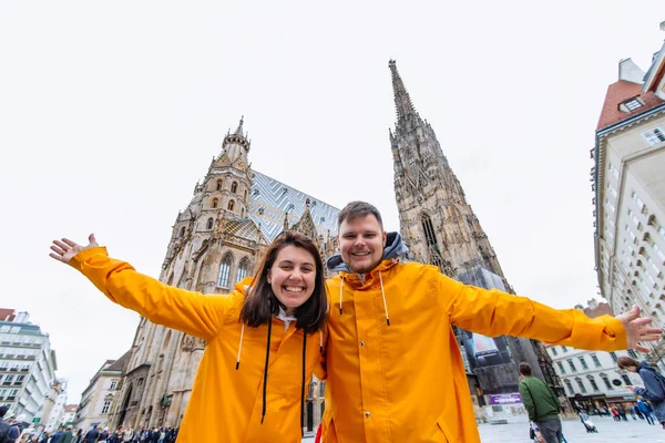 穿着黄色雨衣的夫妇在维也纳大教堂复制空间前旅行 — 图库照片
