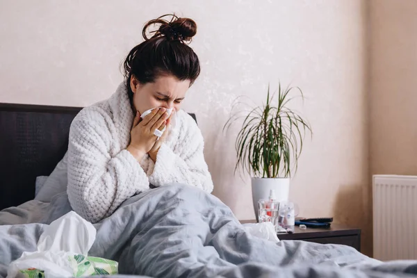 Yataktaki genç hasta kadın hap içiyor. Boşluğu kopyala