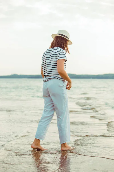 deniz Plajı tarafından yürüyen beyaz kıyafetler kadın