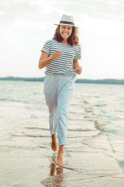 deniz Plajı tarafından yürüyen beyaz kıyafetler kadın