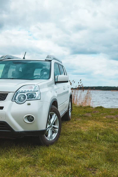 white suv car at lake beach overcast weather. copy space