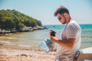 Yazın arka plandaki sahil sahili haritasında bir adam var.