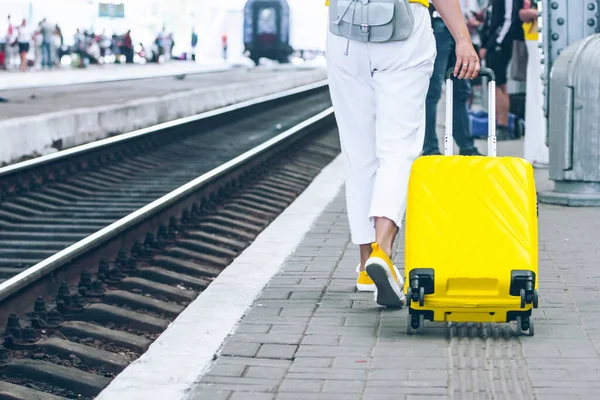 woman with yellow bag at railway station copy space