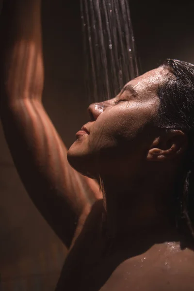 若いきれいな女性がシャワーを浴びてる ライトが低い — ストック写真