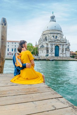 Arka planda Büyük Kanal Saint Maria Kilisesi manzaralı iskelede kucaklaşan çift. Boşluğu kopyala