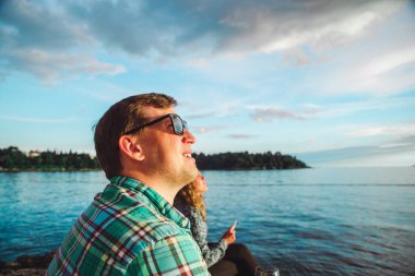 Sahilde oturmuş gün batımını seyreden bir adam. kopyalama alanı. yaz tatili