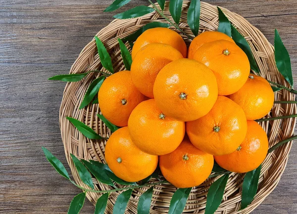sepet içinde mandalina ve yeşil yapraklar