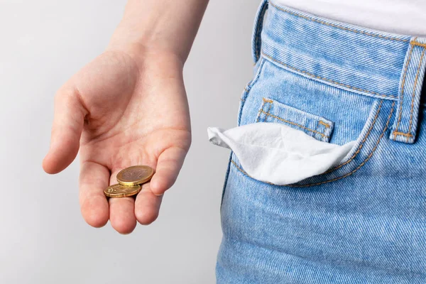 Mujer mostrando bolsillos vacíos y pocas monedas en la mano. Concepto de bancarrota . —  Fotos de Stock