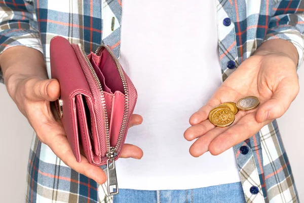 Jugendliche halten leere Brieftasche und letzte Münzen in der Hand. Konkurskonzept. — Stockfoto