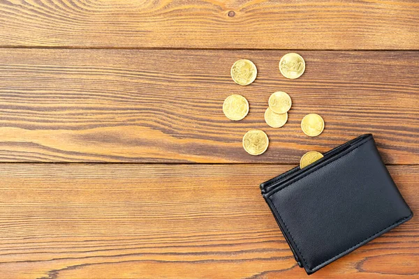 Wallet with scattered euro coins at wooden background. — Stock Photo, Image