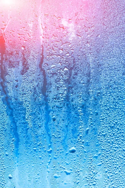 Naturlig bakgrund med kondens på Fönstren, hög luftfuktighet. Strukturer av vattendroppar av regn flöde ner glaset — Stockfoto
