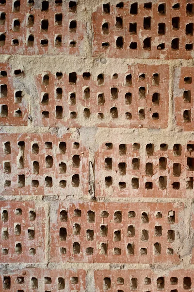 Big old red-orange brick wall background with little holes. Vint