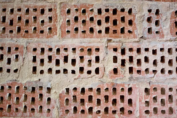 Big old red-orange brick wall background with little holes. Vint