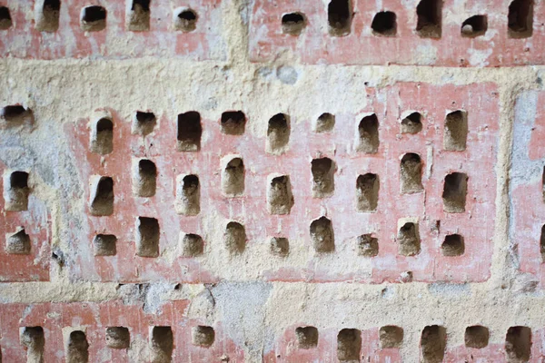 Big old red-orange brick wall background with little holes. Vint